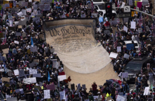 Protestors in Los Angeles hold up a giant banner reading “We the People,” echoing the first three words of the U.S. Constitution’s preamble. The Constitution is the living foundation of American democracy, setting the rules that protect American freedoms.